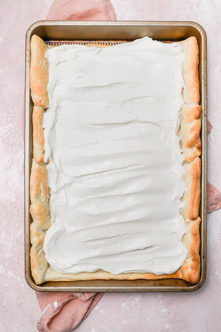 Baked crescent roll crust topped with cream cheese frosting.