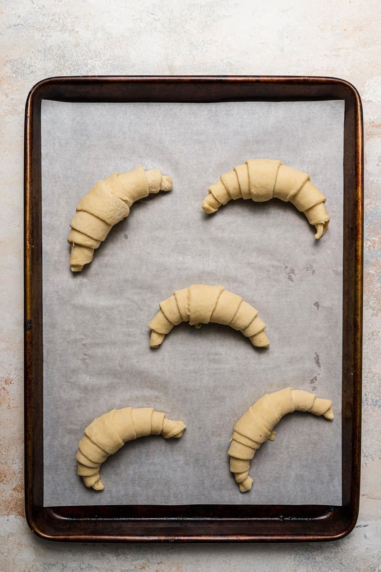 Croissants on baking sheet while proofing.