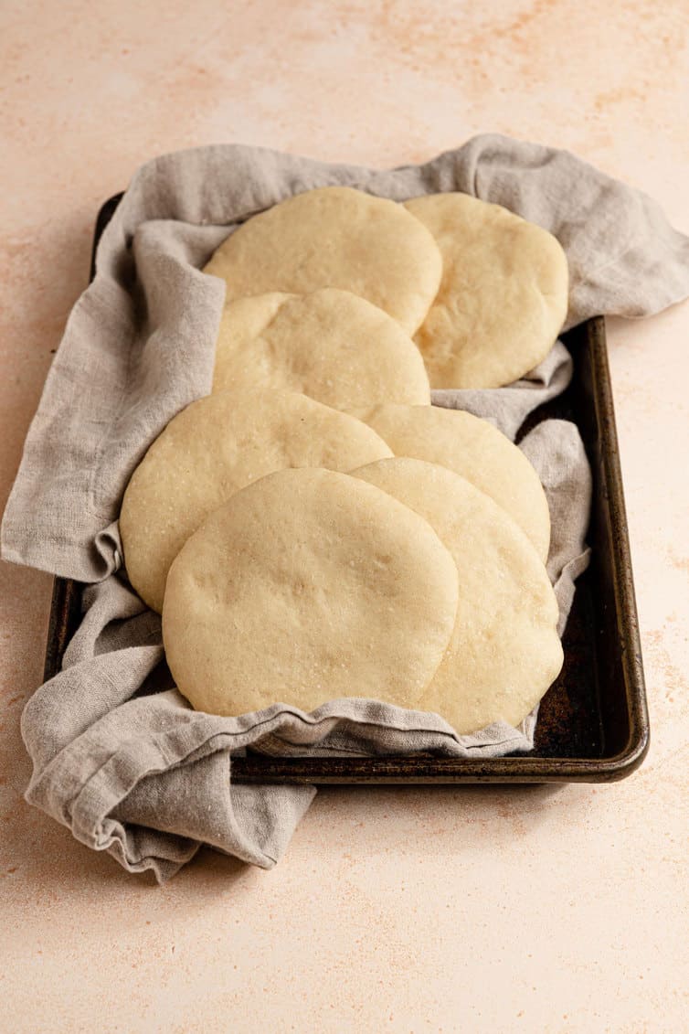 Fresh pita bread on a kitchen towel.