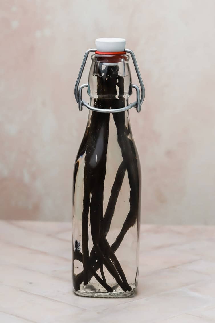 Glass bottle filled with vanilla beans and vodka.