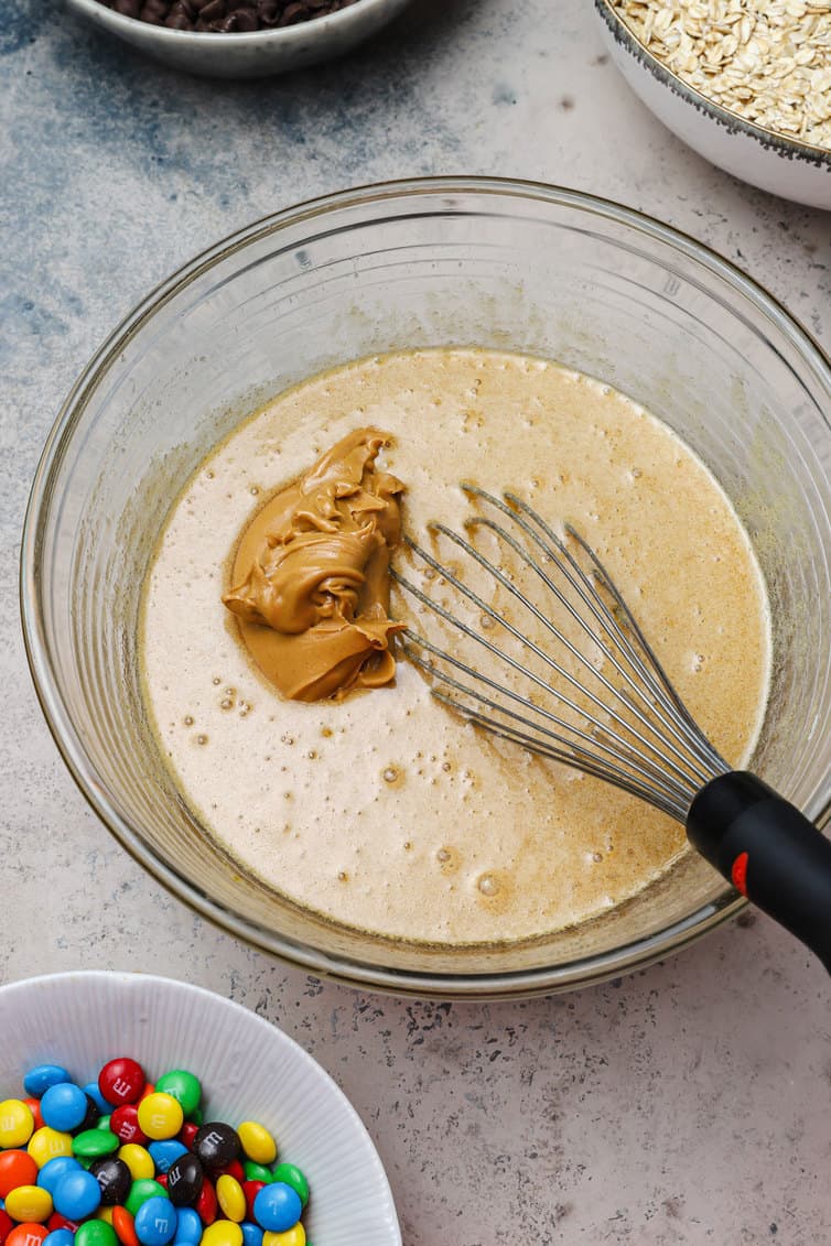 Peanut butter being stirred into an egg mixture.