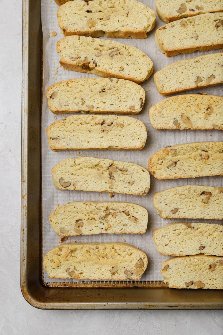 Biscotti arranged cut-side-up on a baking sheet.