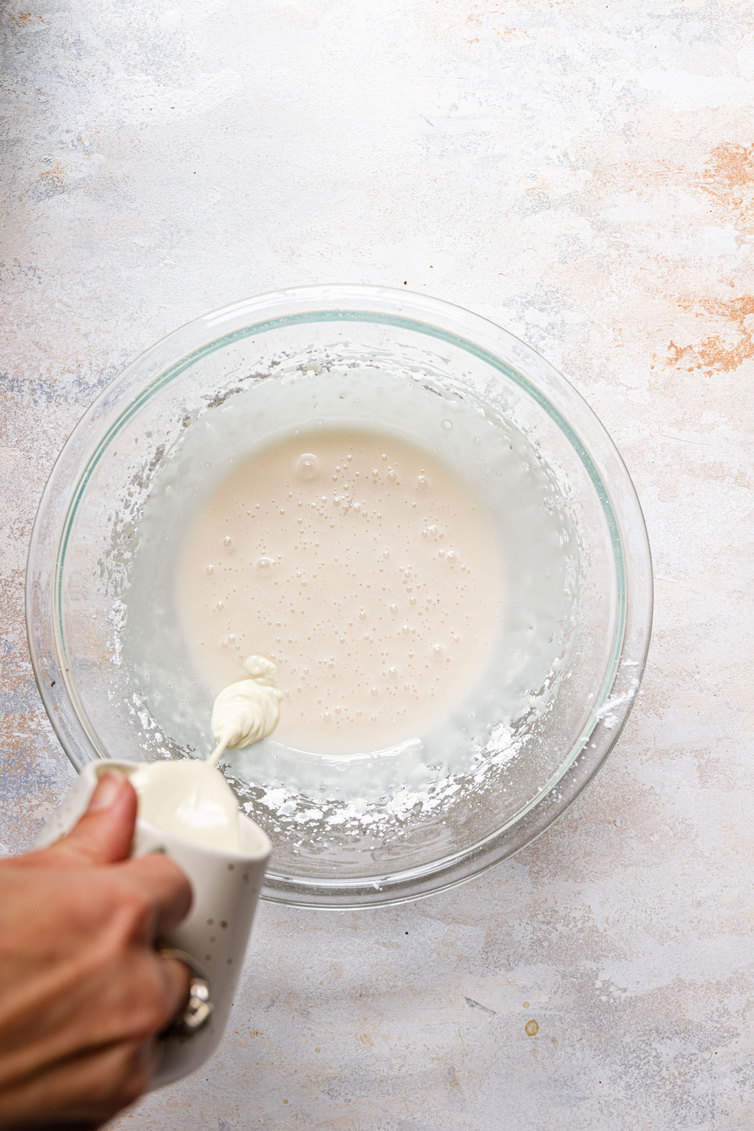 Pouring melted white chocolate into a bowl.