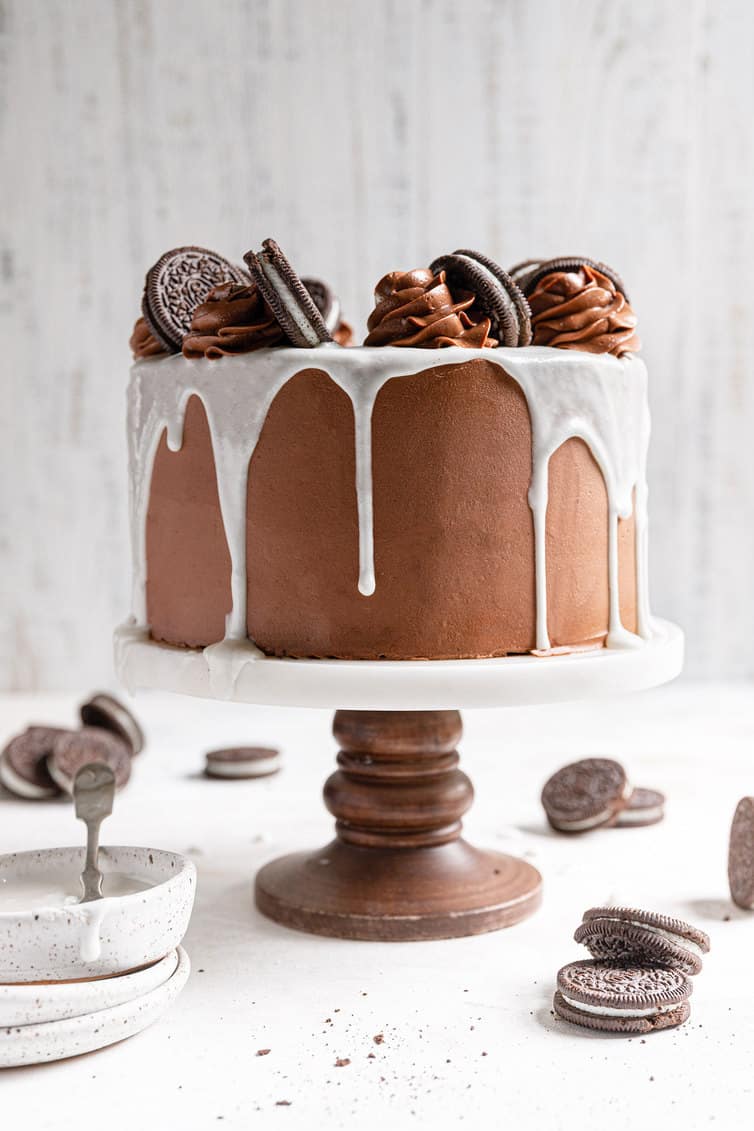 Oreo cake with white glaze, chocolate rosettes and Oreos on top.
