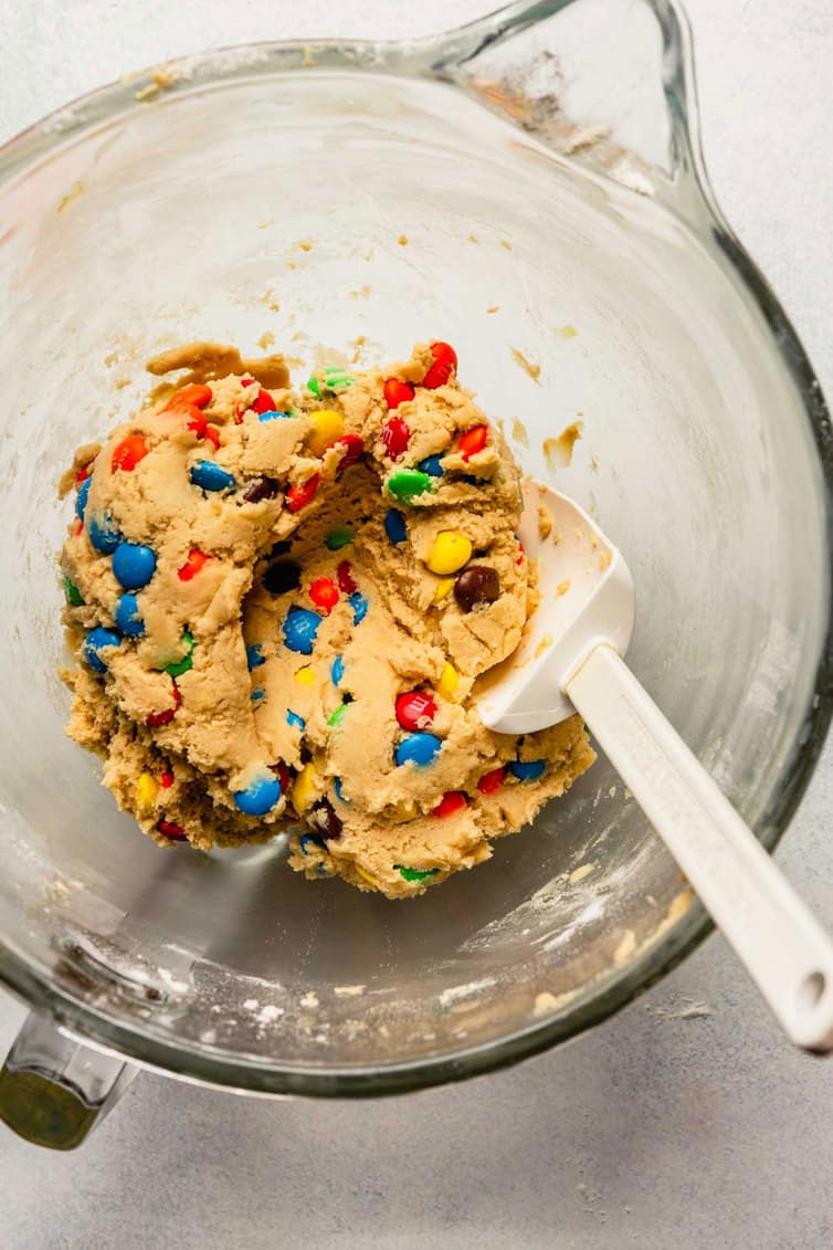 M&M cookie dough in glass mixing bowl.