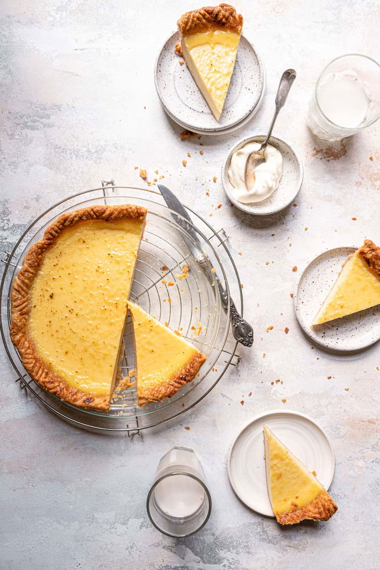 Overhead photo of buttermilk pie sliced with pieces plated.