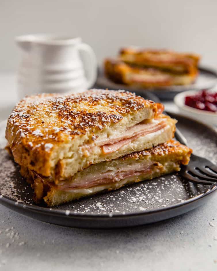 Monte Cristo sandwich cut in half and stacked, dusted with powdered sugar.