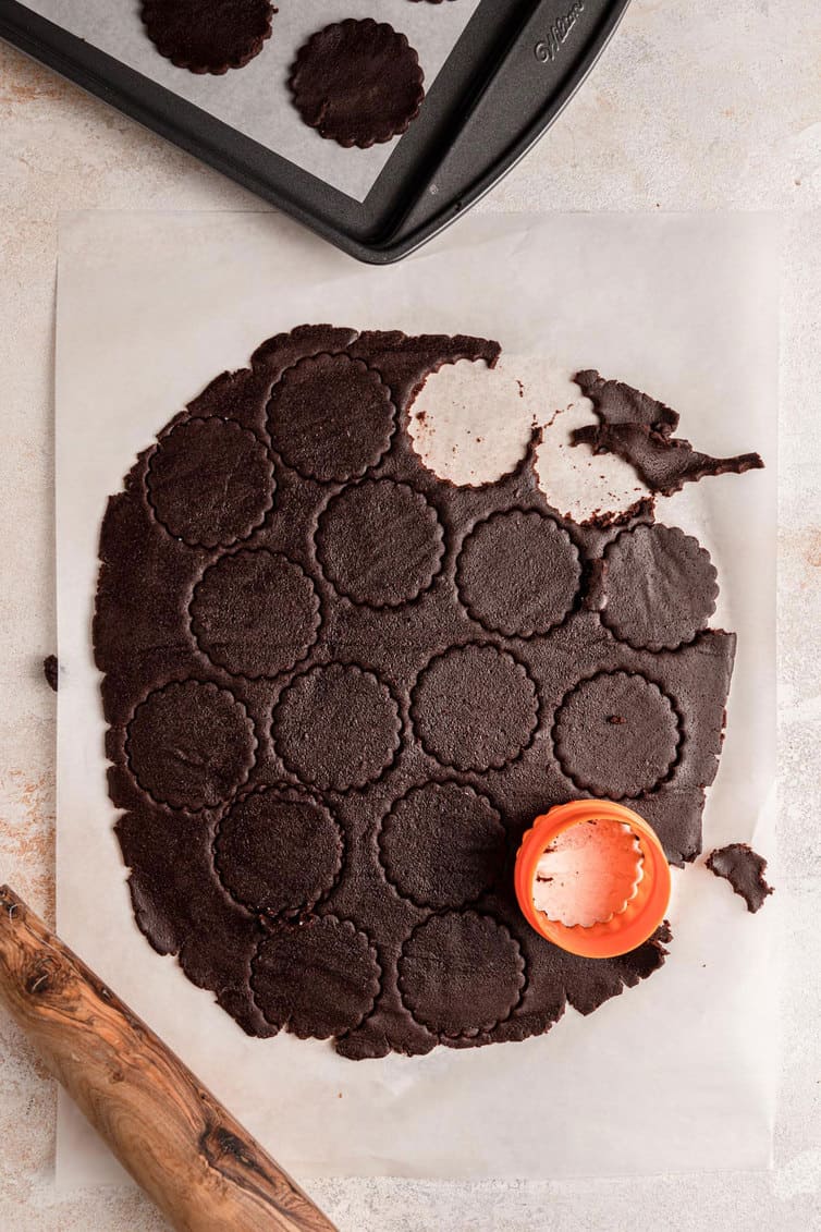 Cutting out circles from chocolate cookie dough.