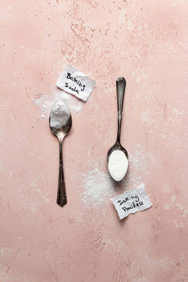 A spoon holding baking powder and a spoon holding baking powder.