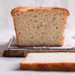 An English muffin bread loaf sliced to show the nooks and crannies of the bread.