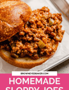 A sloppy joe sandwich on a parchment paper lined metal tray with a pink rectangle at the bottom with the words homemade sloppy joes in white.