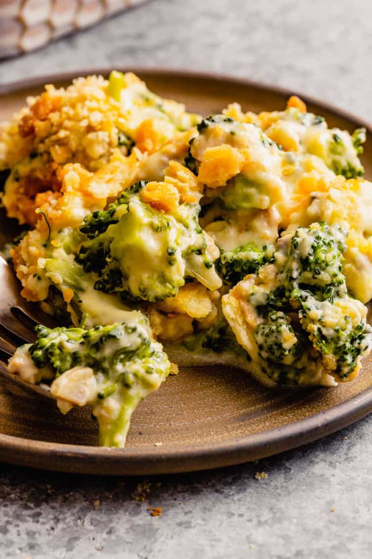 A picture from the side of broccoli casserole on a brown plate on a grey counter.