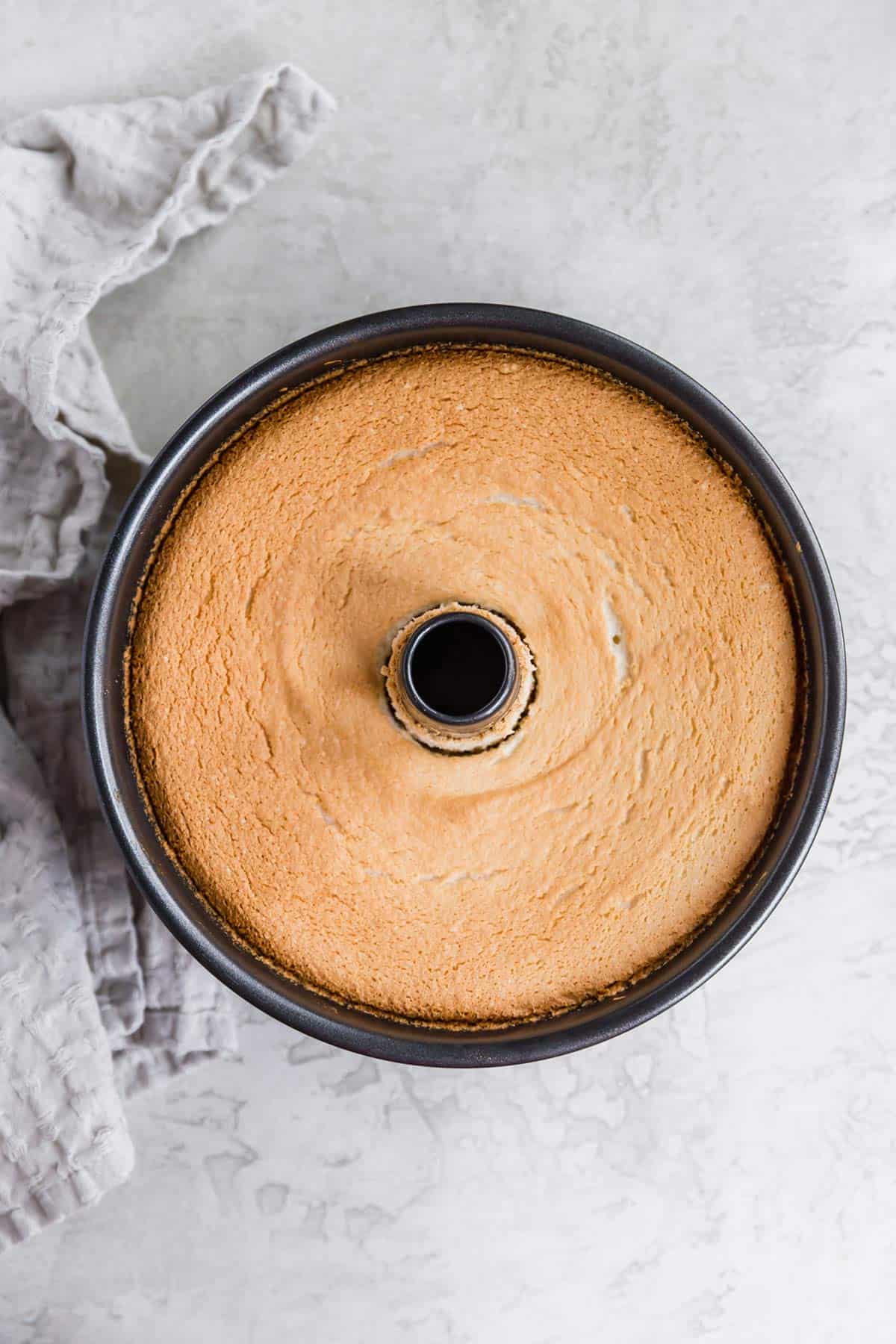 Overhead photo of a baked angel food cake still in tube pan.