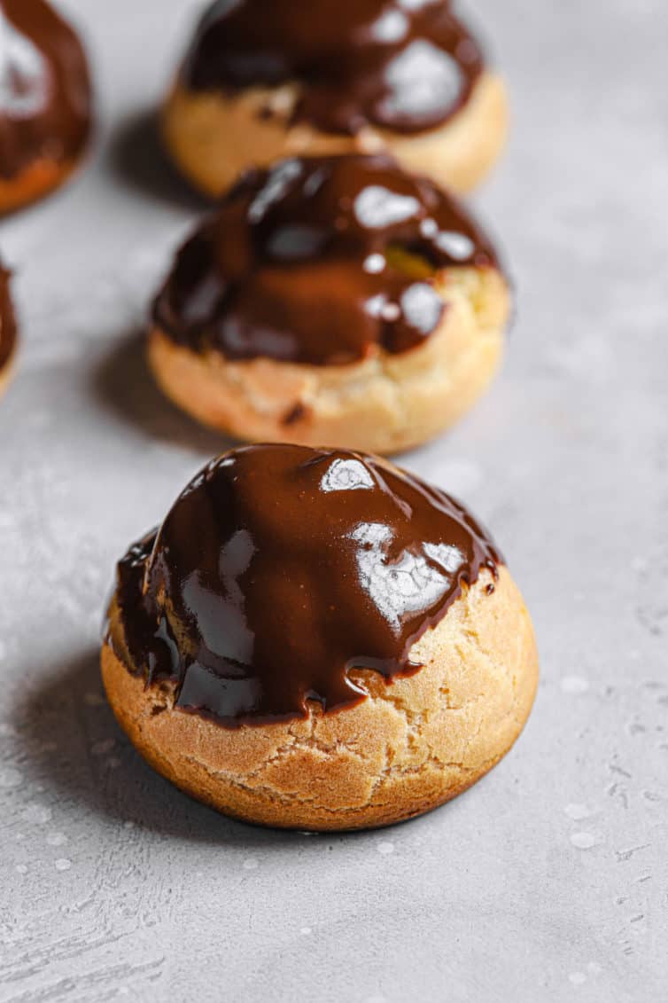 Chocolate dipped cream puffs on the counter.