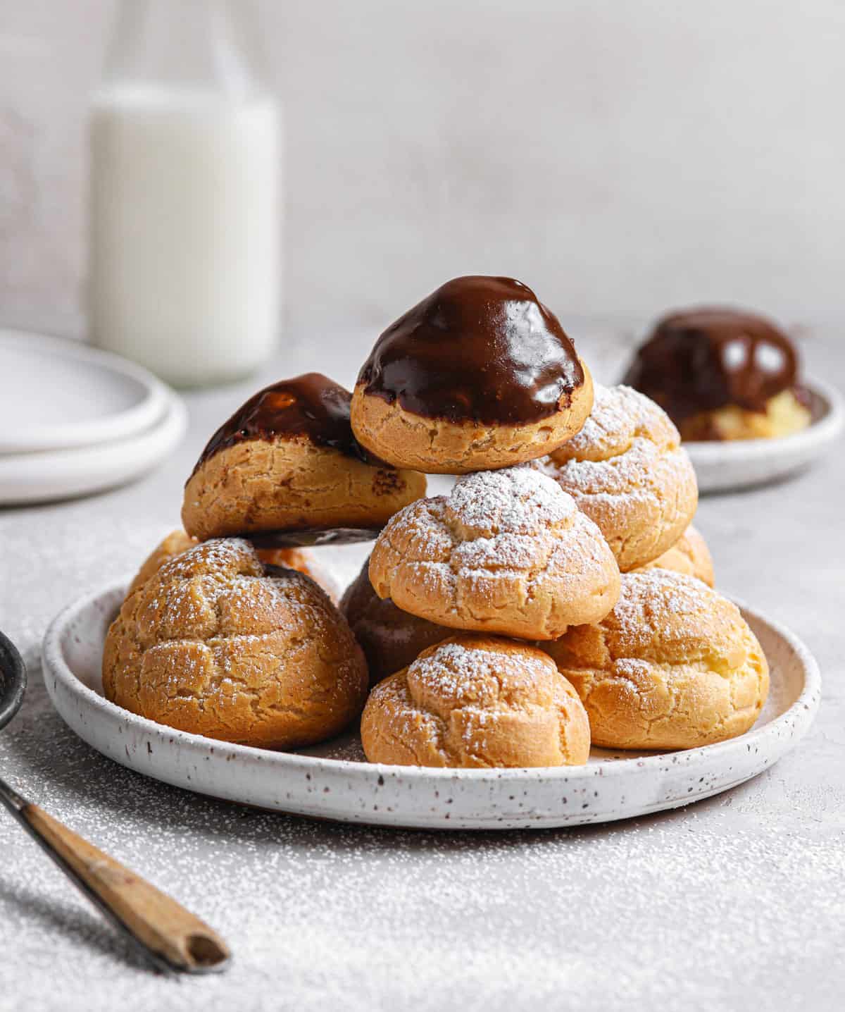 Stack of cream puffs on a plate.