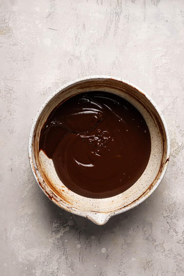 A light brown bowl filled with melted chocolate sauce.