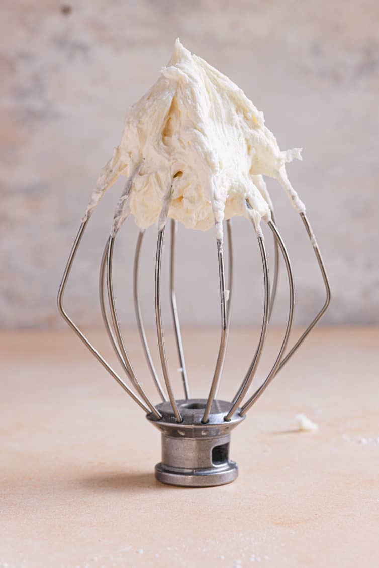 A full wire whisk topped with vanilla buttercream frosting.