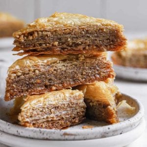 A stack of 3 slices of baklava on a white plate.