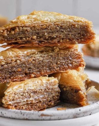 A stack of 3 slices of baklava on a white plate.