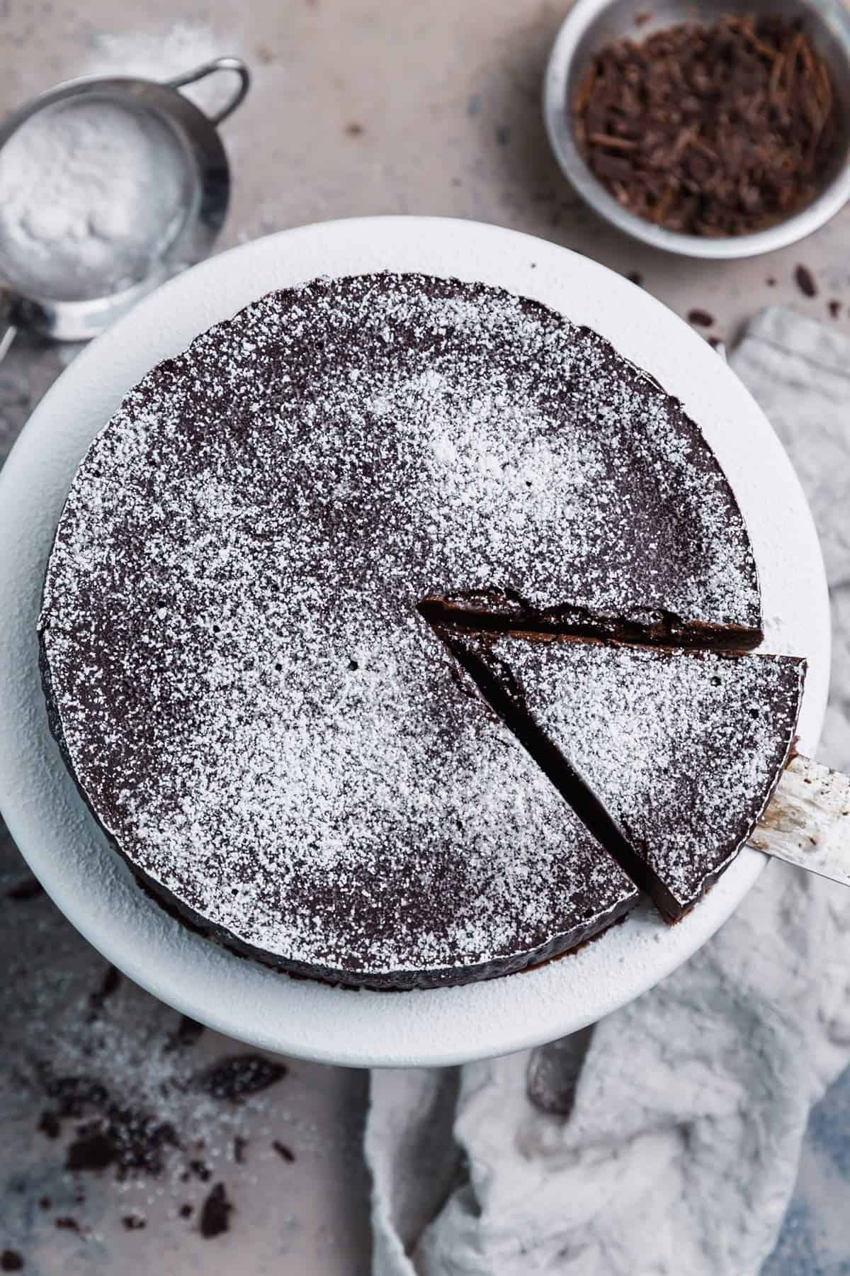 An overhead photo of flourless chocolate cake dusted with powdered sugar.