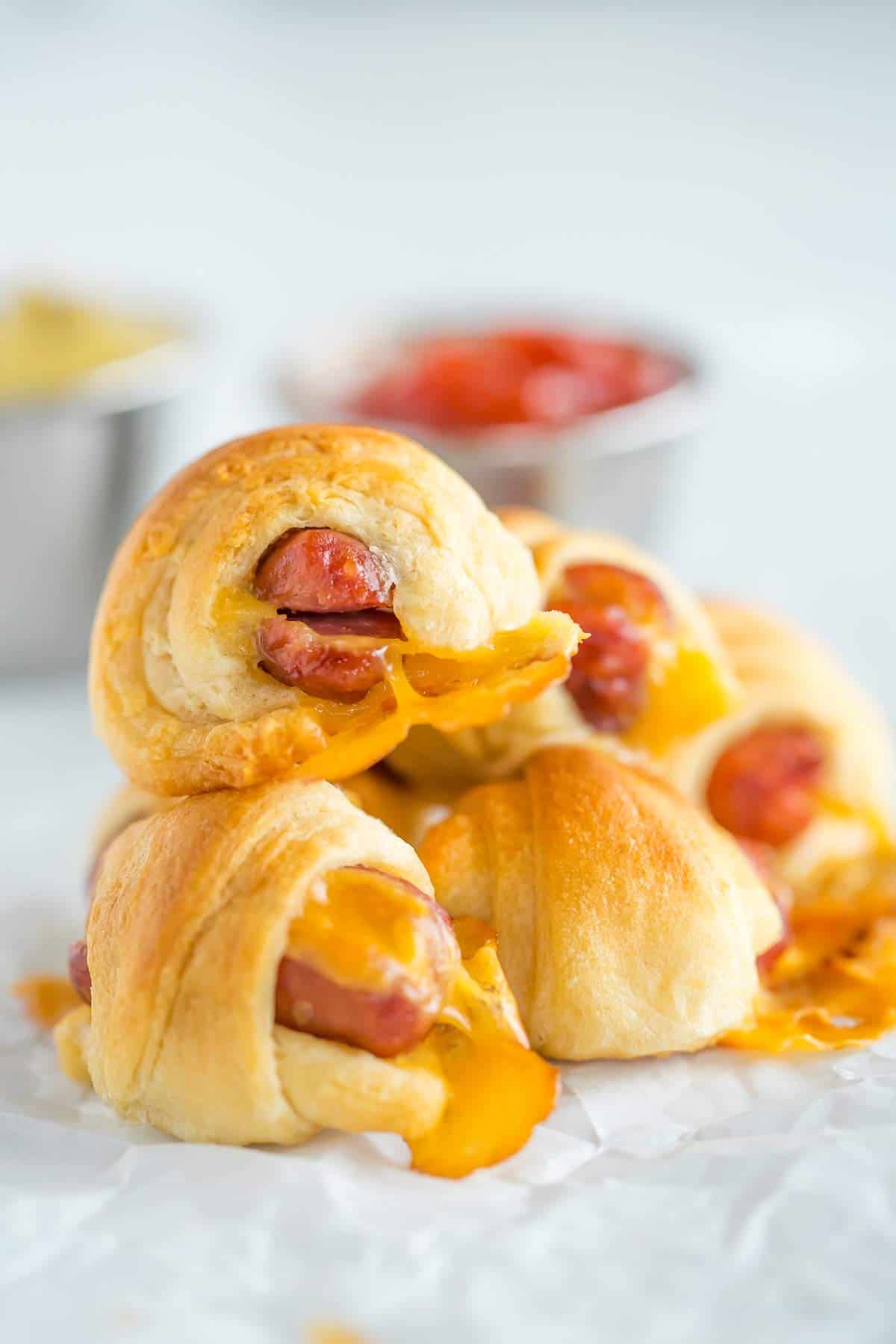 Cheesy pigs in a blanket stacked on top of each other.
