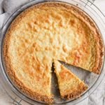 A square photo of a crack pie with a slice cut in the pan in the bottom right side of the pie.