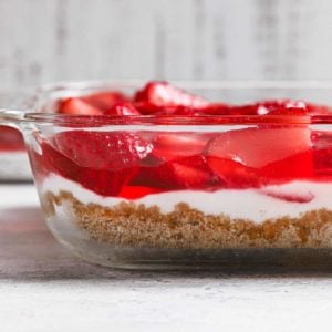 A glass baking dish with strawberry pretzel salad layers.