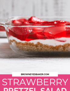 A picture of strawberry pretzel salad in a glass container from the side to show the different layers with a pink box at the bottom with the words strawberry pretzel salad.