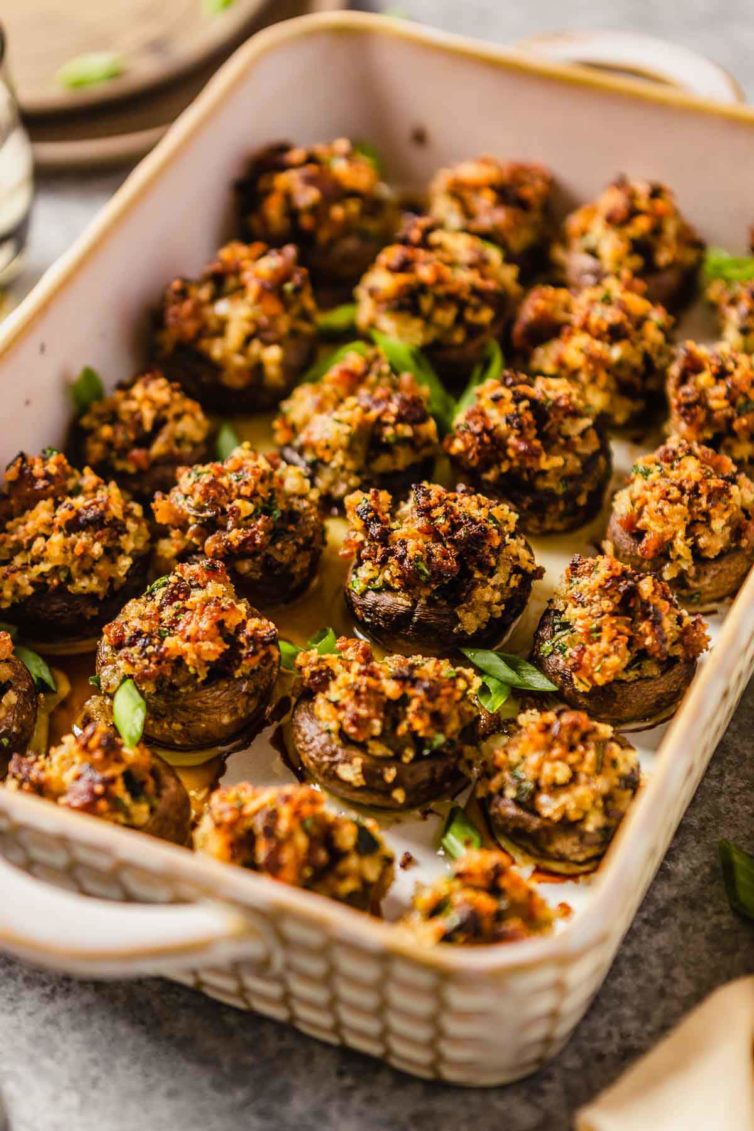 A rectangular baking dish with handles filled with sausage stuffed mushrooms.