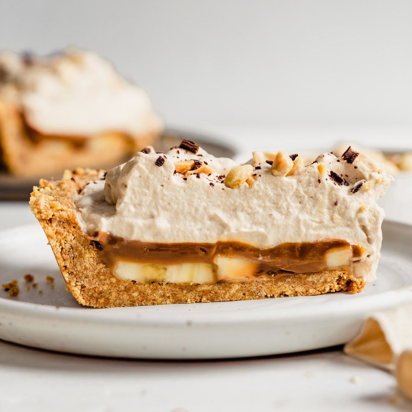 Slice of banoffee pie on a white plate.