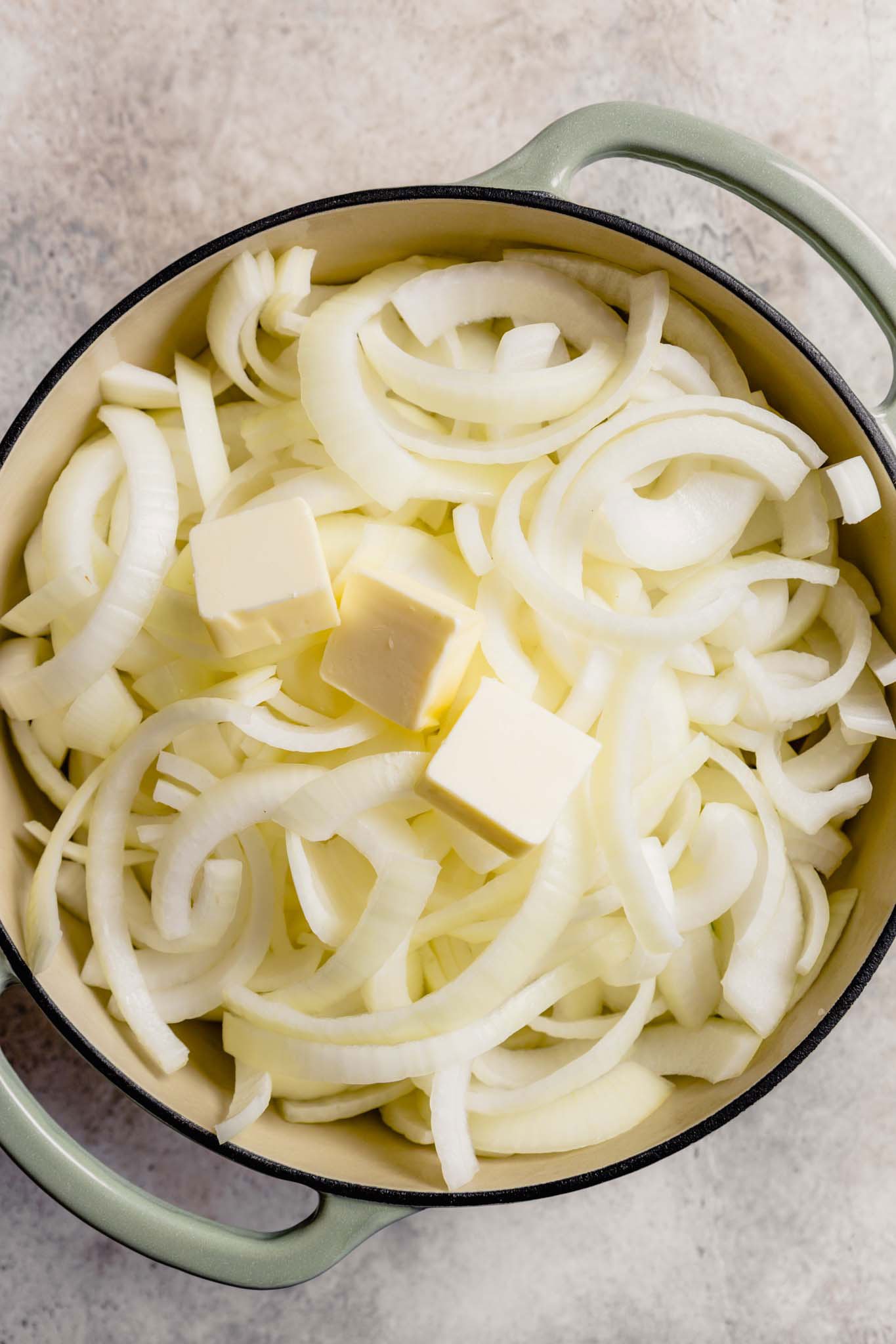 Sliced onions and butter in a pot.