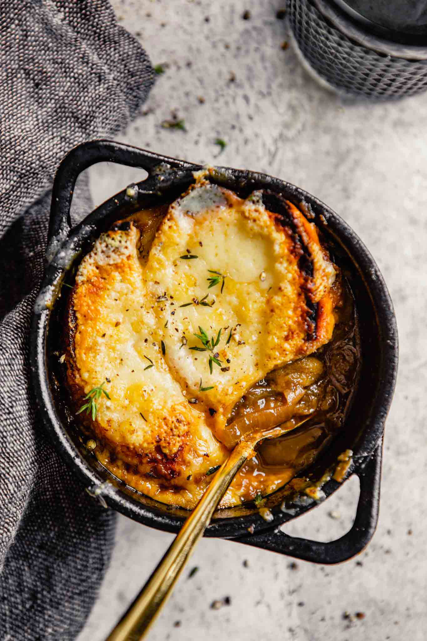 A bowl of French Onion Soup with a spoon inside.