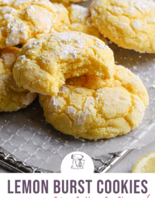 a few lemon crinkle cookies resting on a wire cooling rack with a bite taken out of the cookie in the forefront