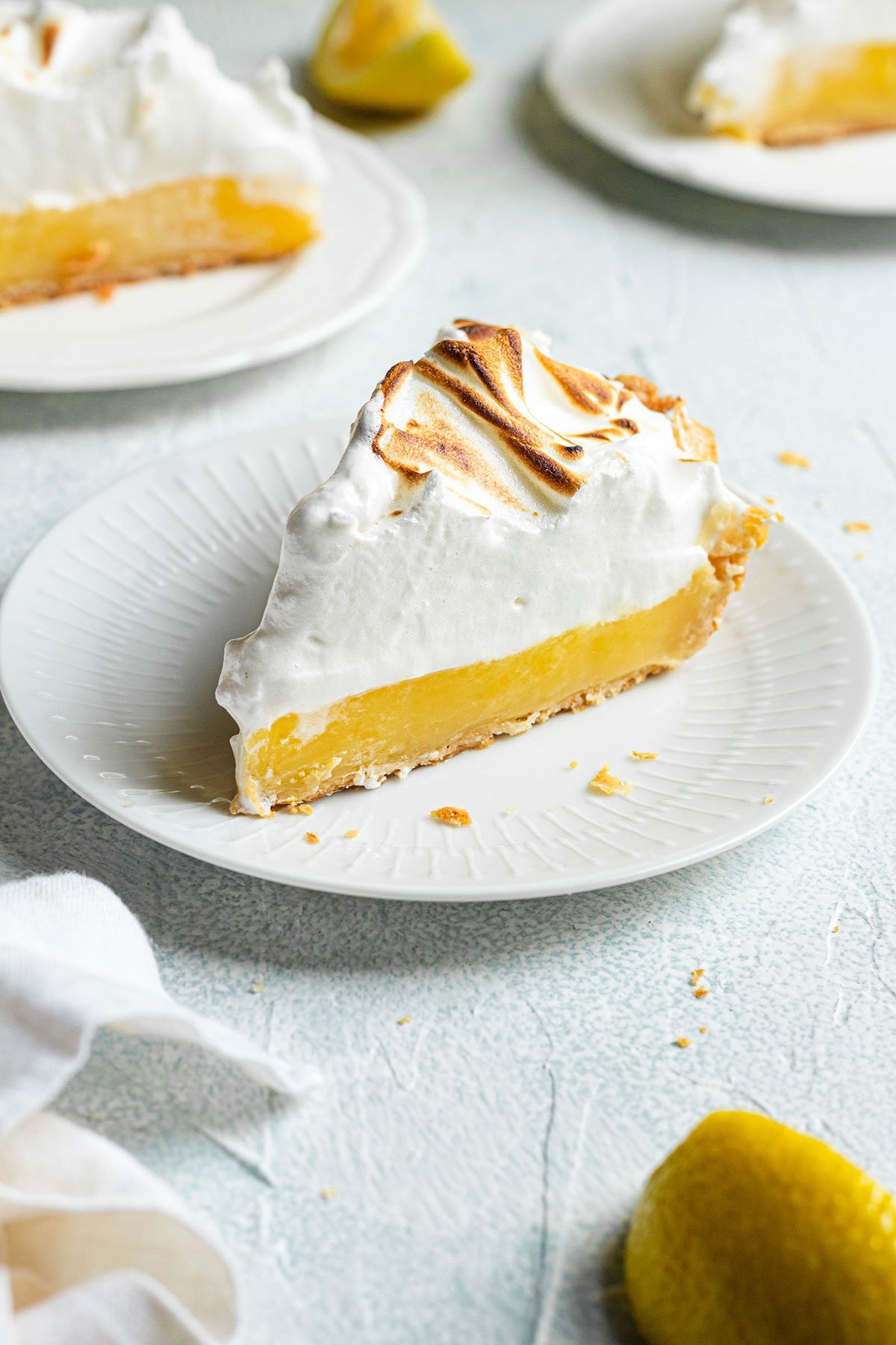 A slice of lemon meringue pie on a white plate.