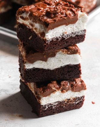 a stack of these fudgey marshmallow crunch brownie bars