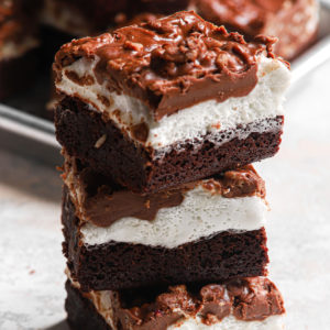 a stack of these fudgey marshmallow crunch brownie bars