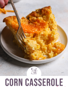 A serving of cheesy creamed corn casserole on a round plate for pinterest