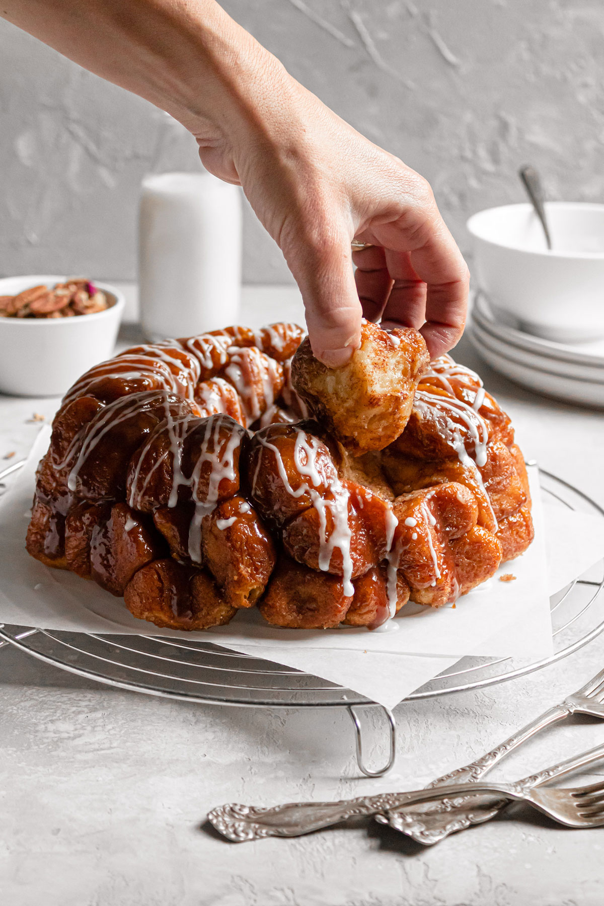 Hand pulling a piece of monkey bread off the loaf.