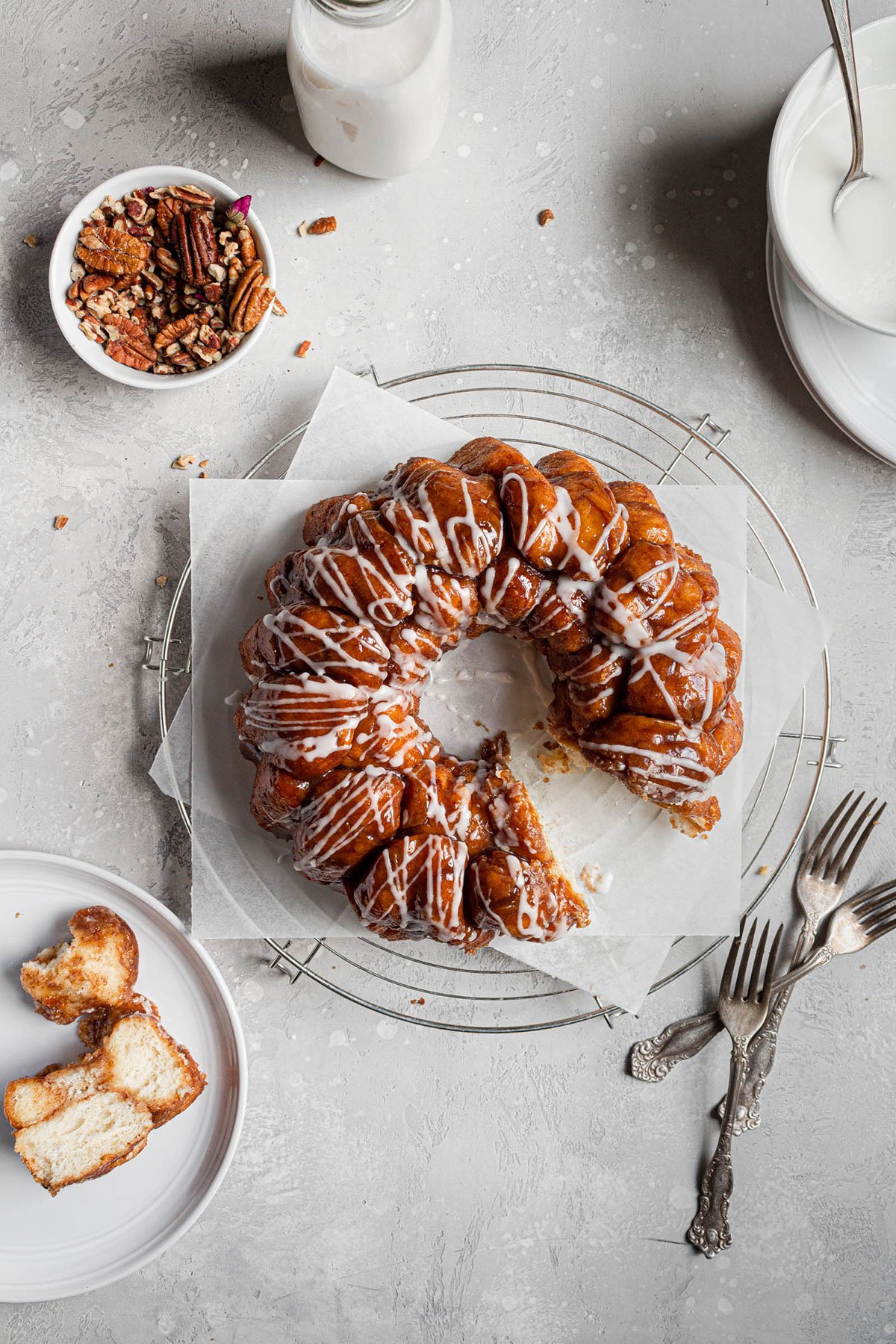 Overhead photo of monkey bread with bowl of pecans and pieces on plate.