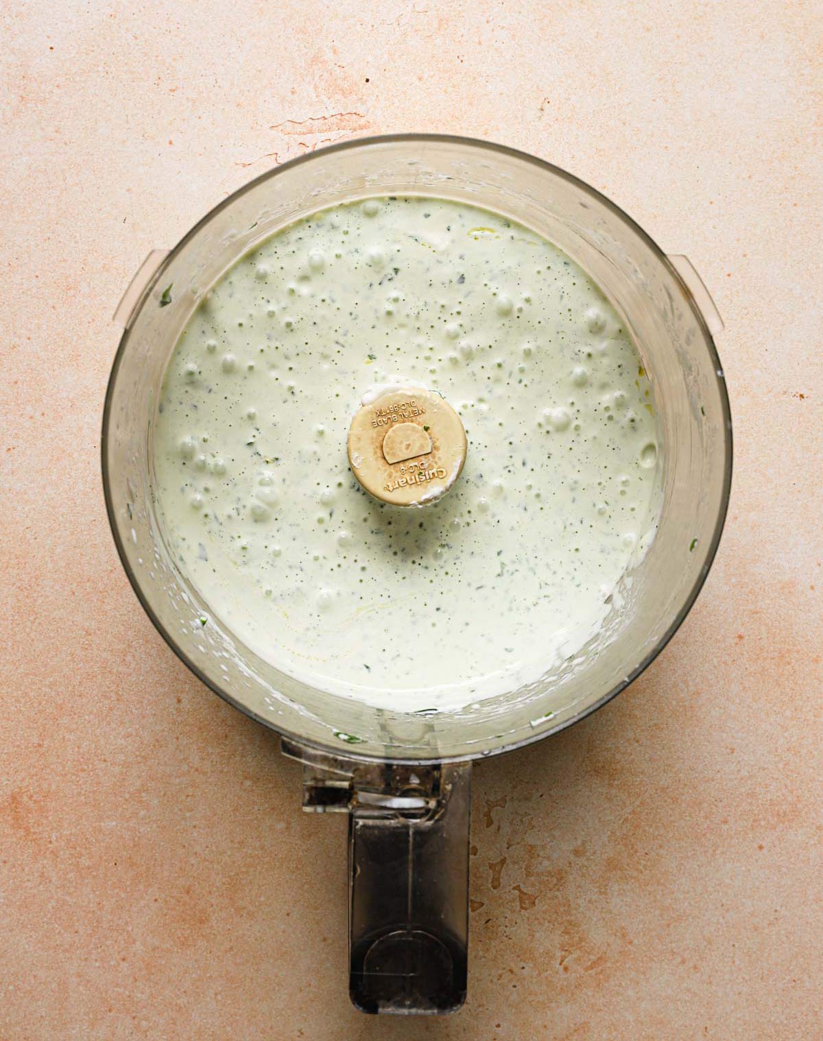 Freshly mixed homemade buttermilk ranch dressing in a food processor bowl.