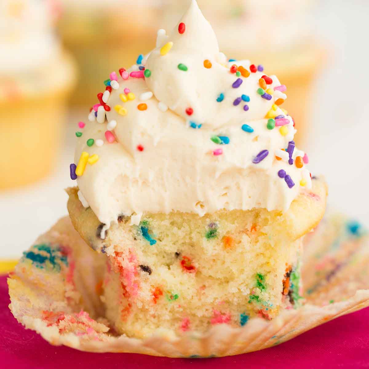 Funfetti cupcake with wrapper removed and bite taken out.