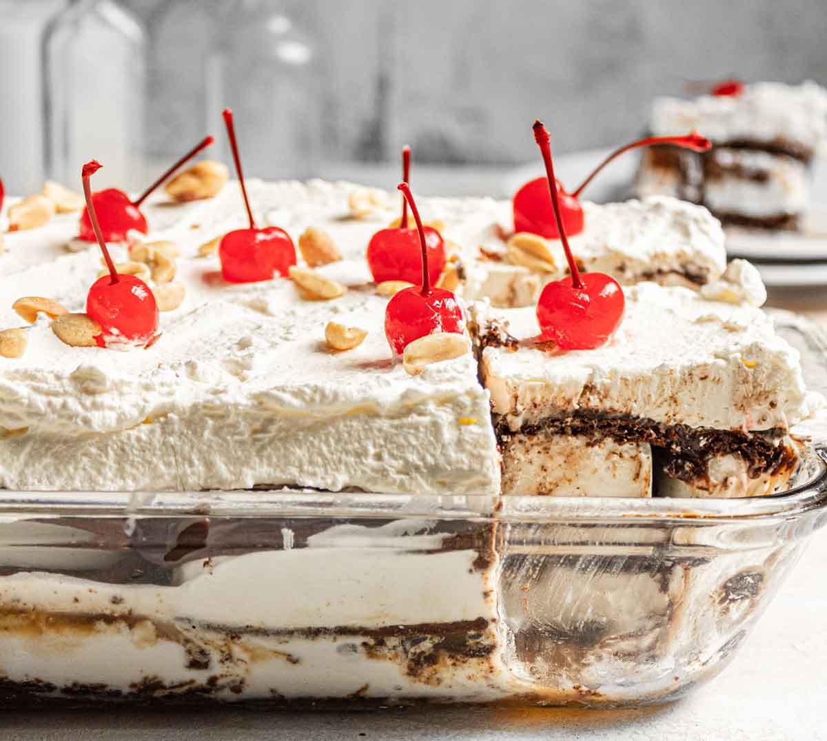 Side view of an assembled ice cream sandwich cake in glass baking dish.