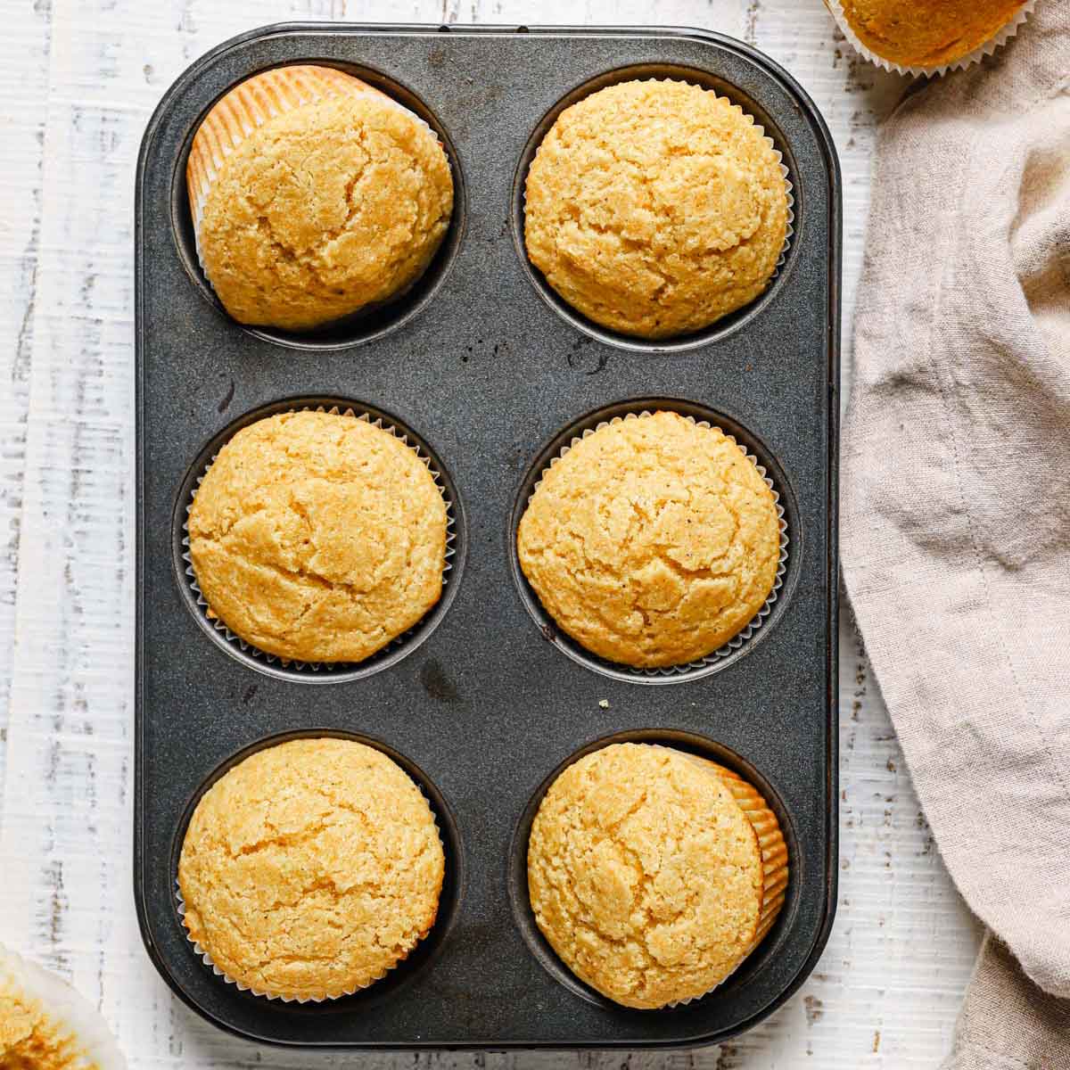 Cornbread muffins in a pan after being baked with two turned sideways.