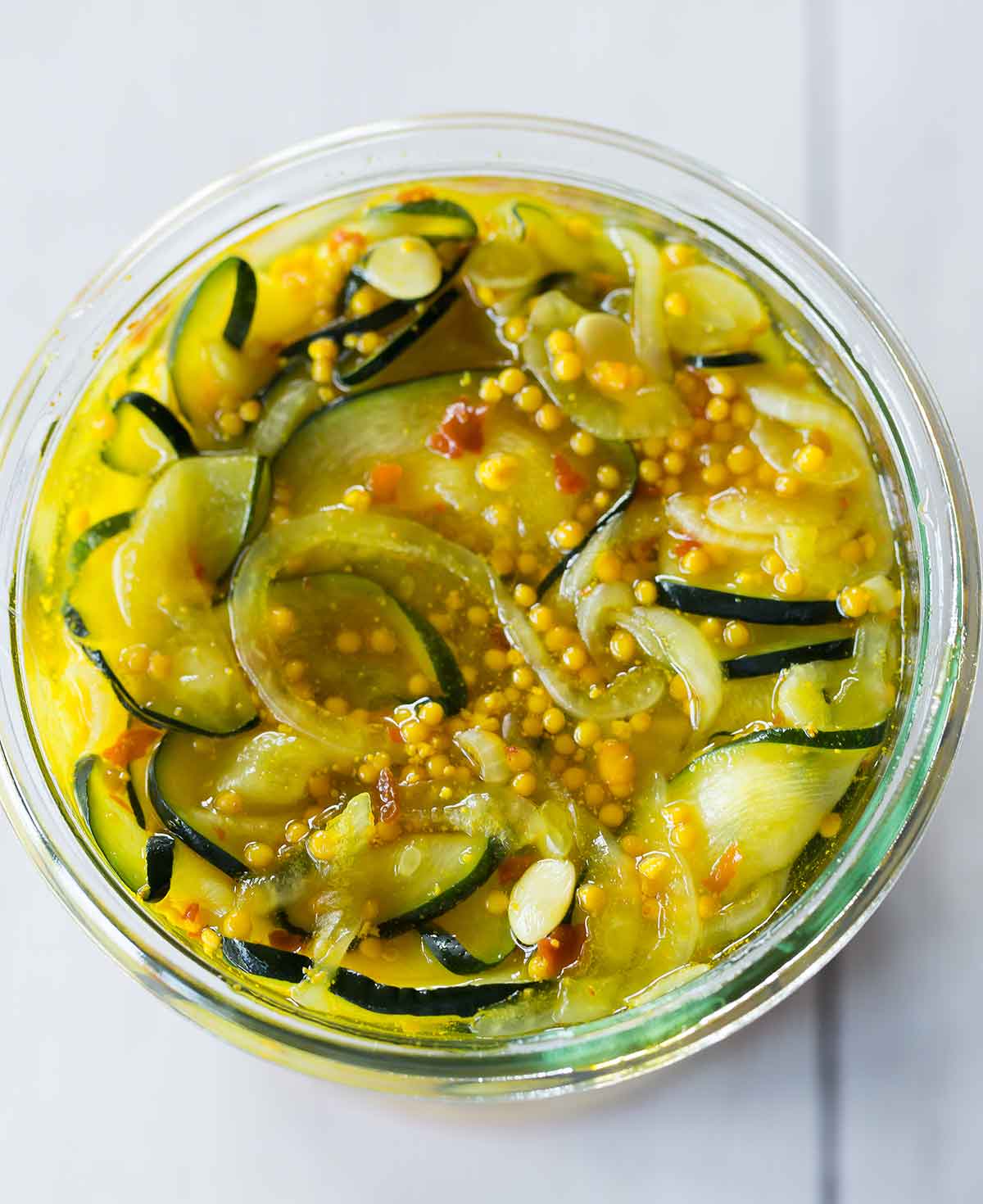 Close up overhead photo of zucchini pickles in glass jar.