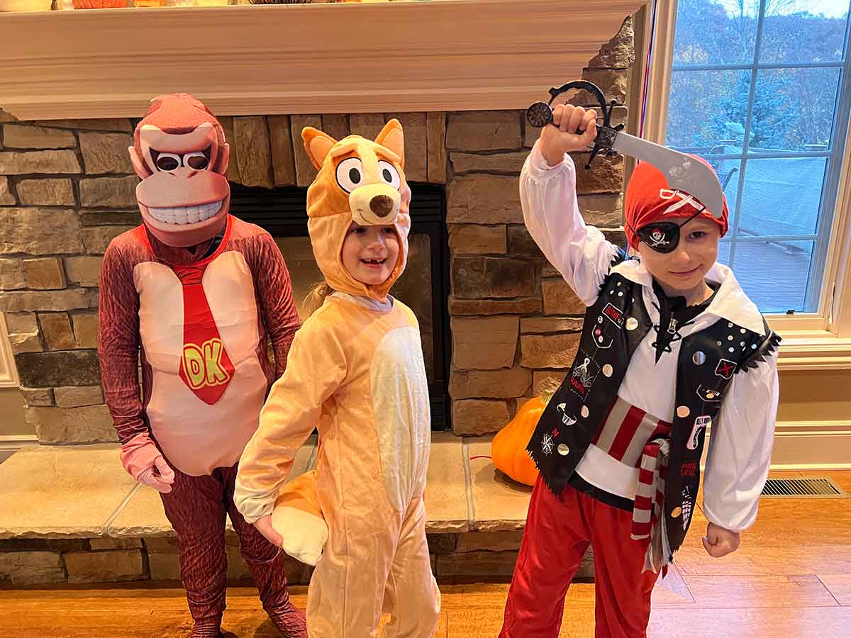 Three kids dressed up for Halloween as Donkey Kong, Bingo, and a pirate.