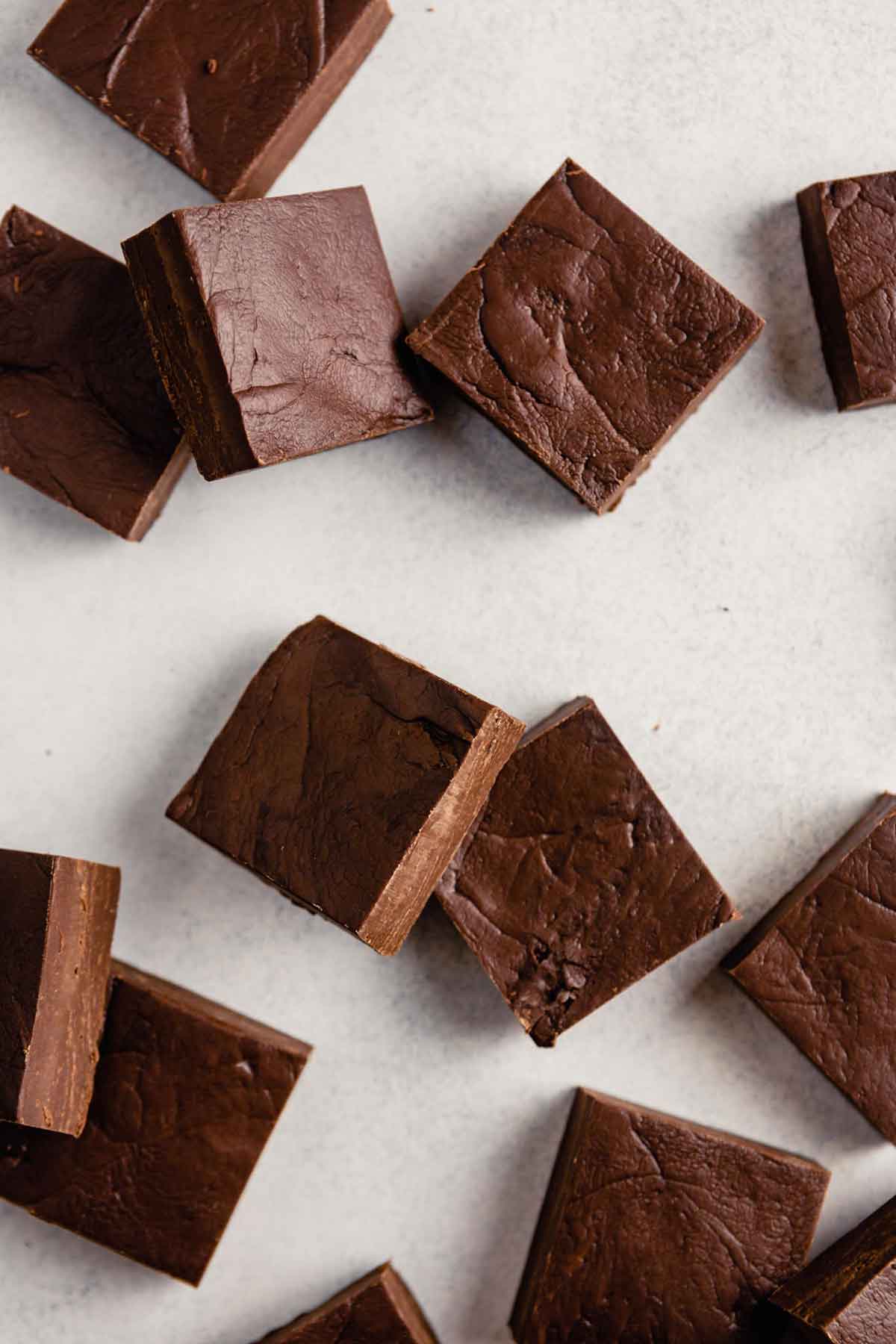 Overhead photo of squares of fudge sitting on a white/grey background.