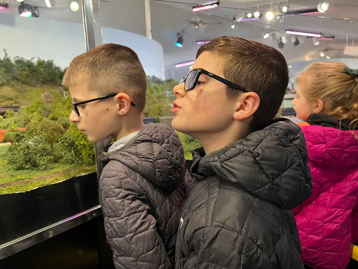 Two boys looking at a model railroad exhibit.