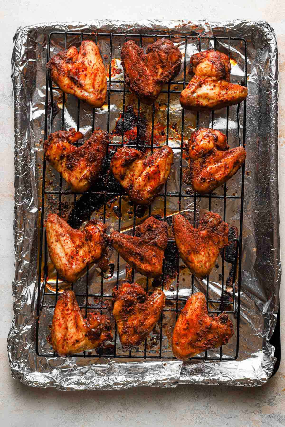 Baked chicken wings on a wire rack set inside a baking sheet.