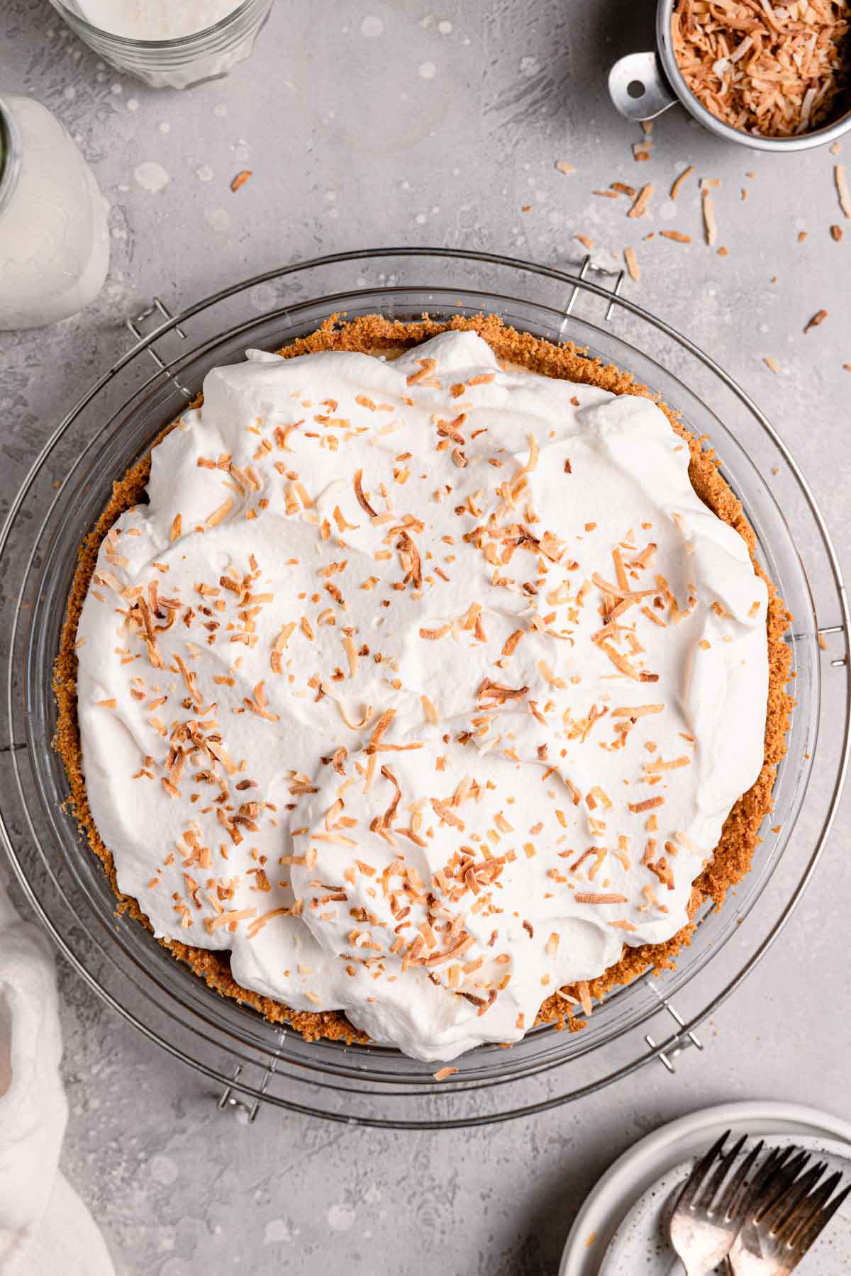 Overhead photo of coconut cream pie in a glass pie plate, garnished with toasted coconut.