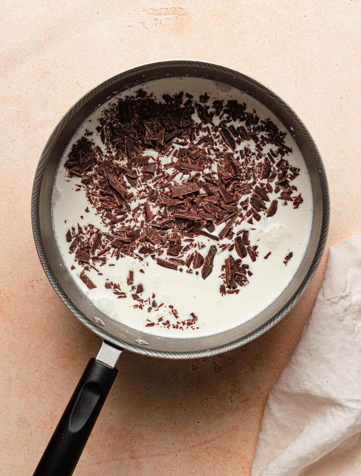 Saucepan with milk and chopped chocolate.